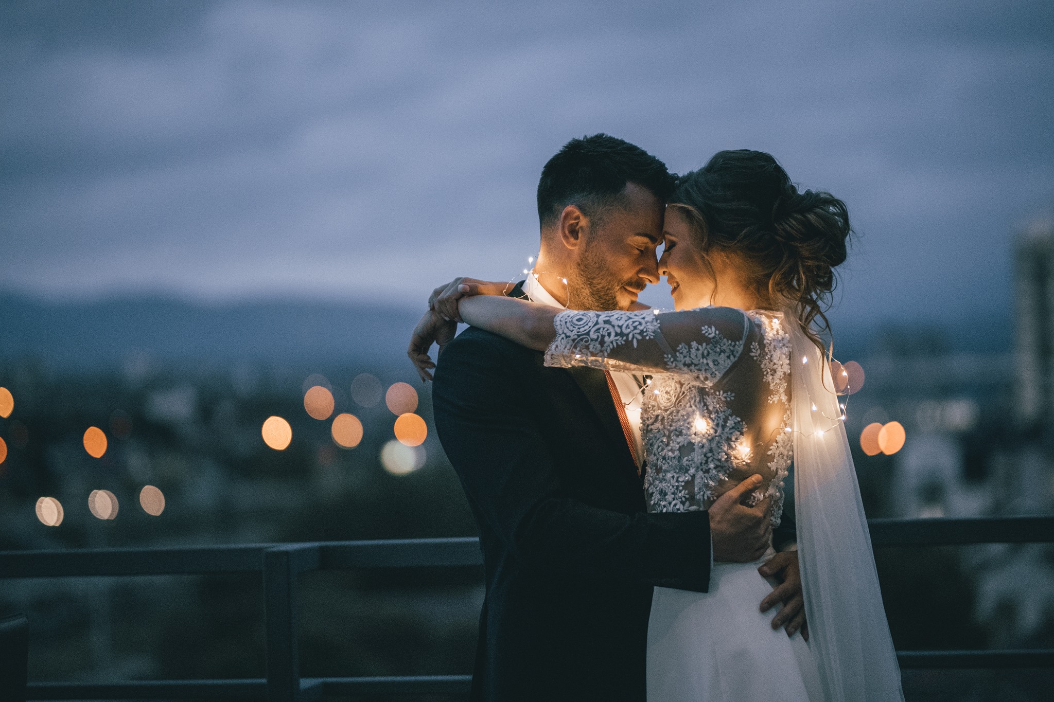 bride and groom embracing surrounded by twinkle lights
