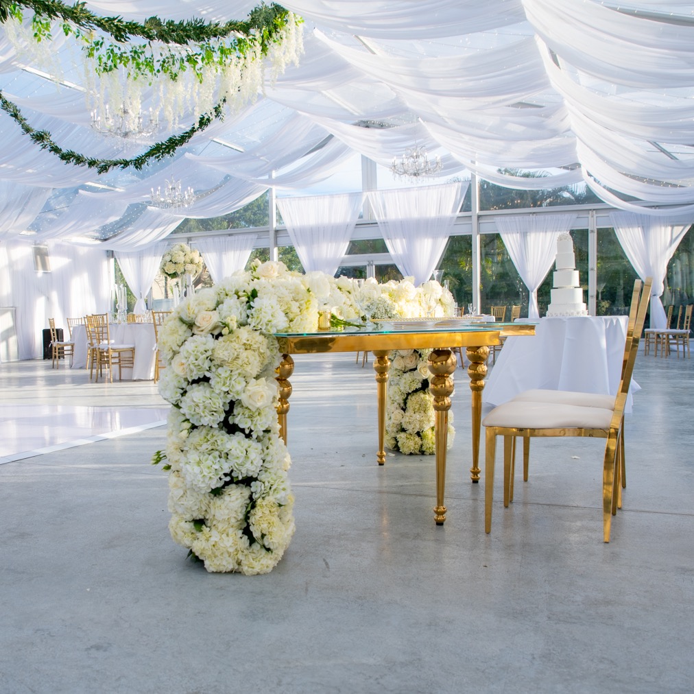 white wedding floral arrangement under a large tent