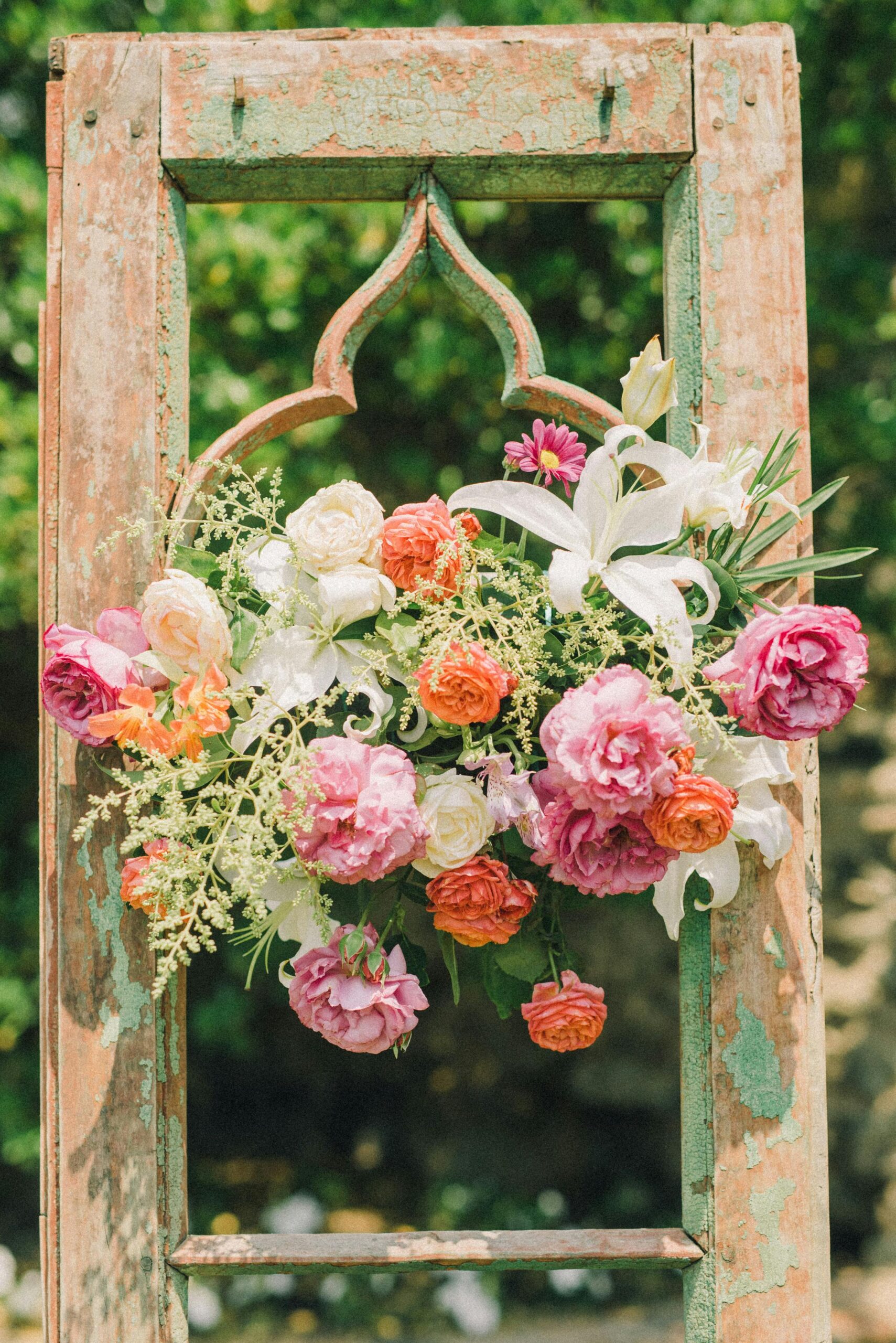 wedding floral arrangement hanging on antique window