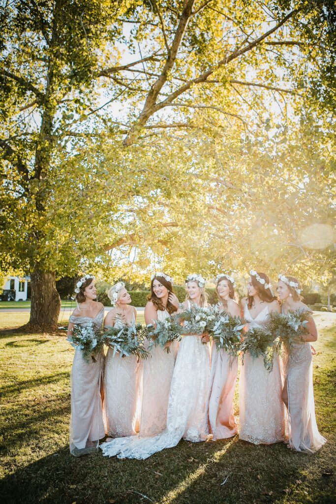 bride smiling with bridesmaids in champagne dresses